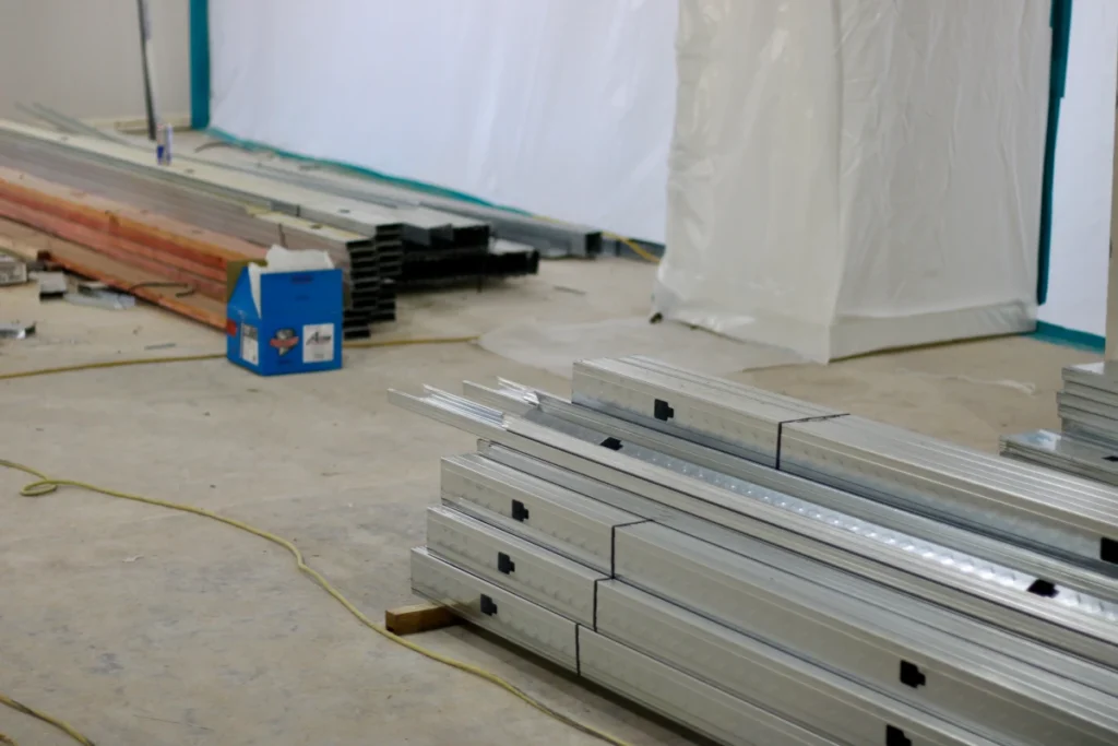 Stacks of metal beams in construction area.