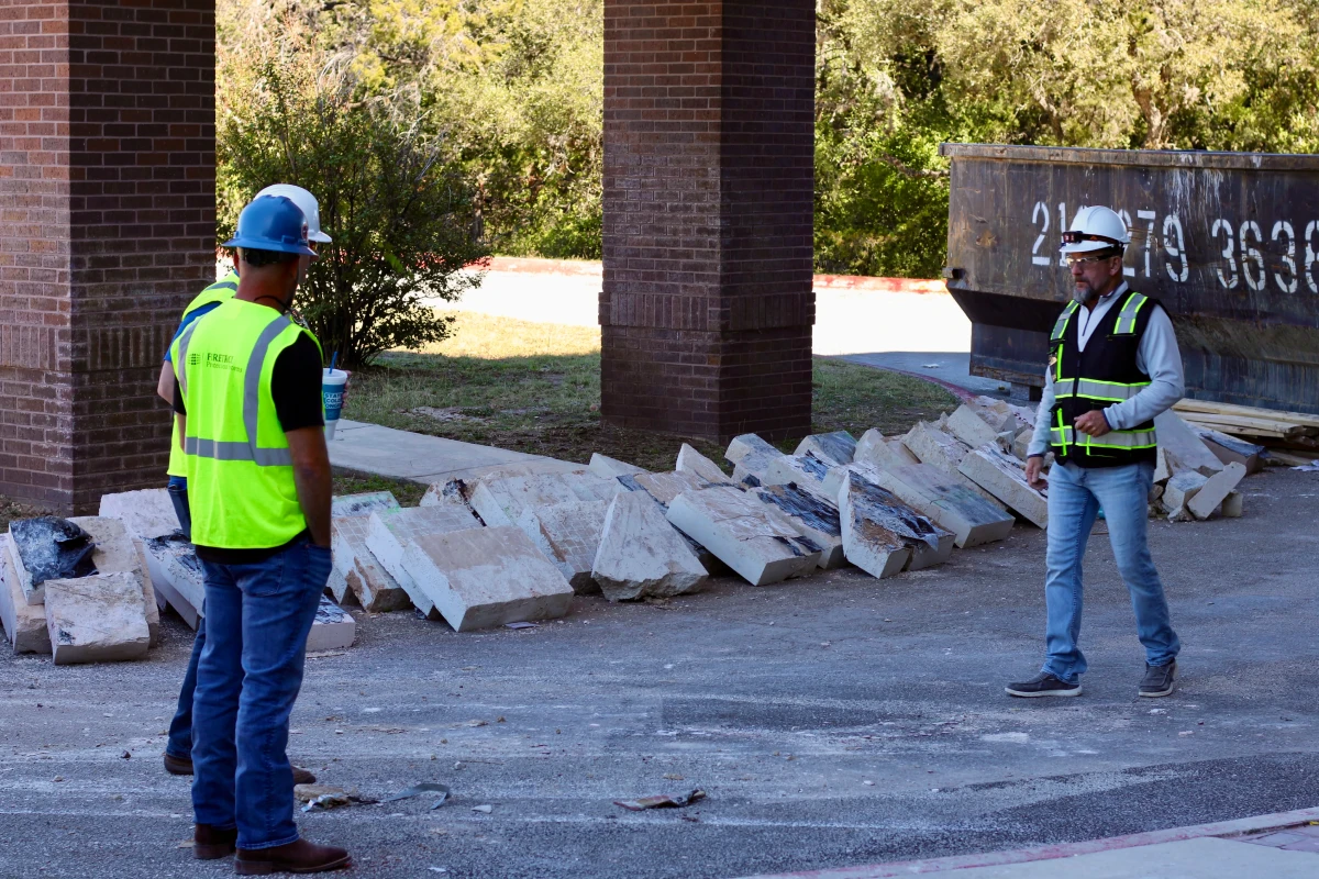 Construction workers near building materials.